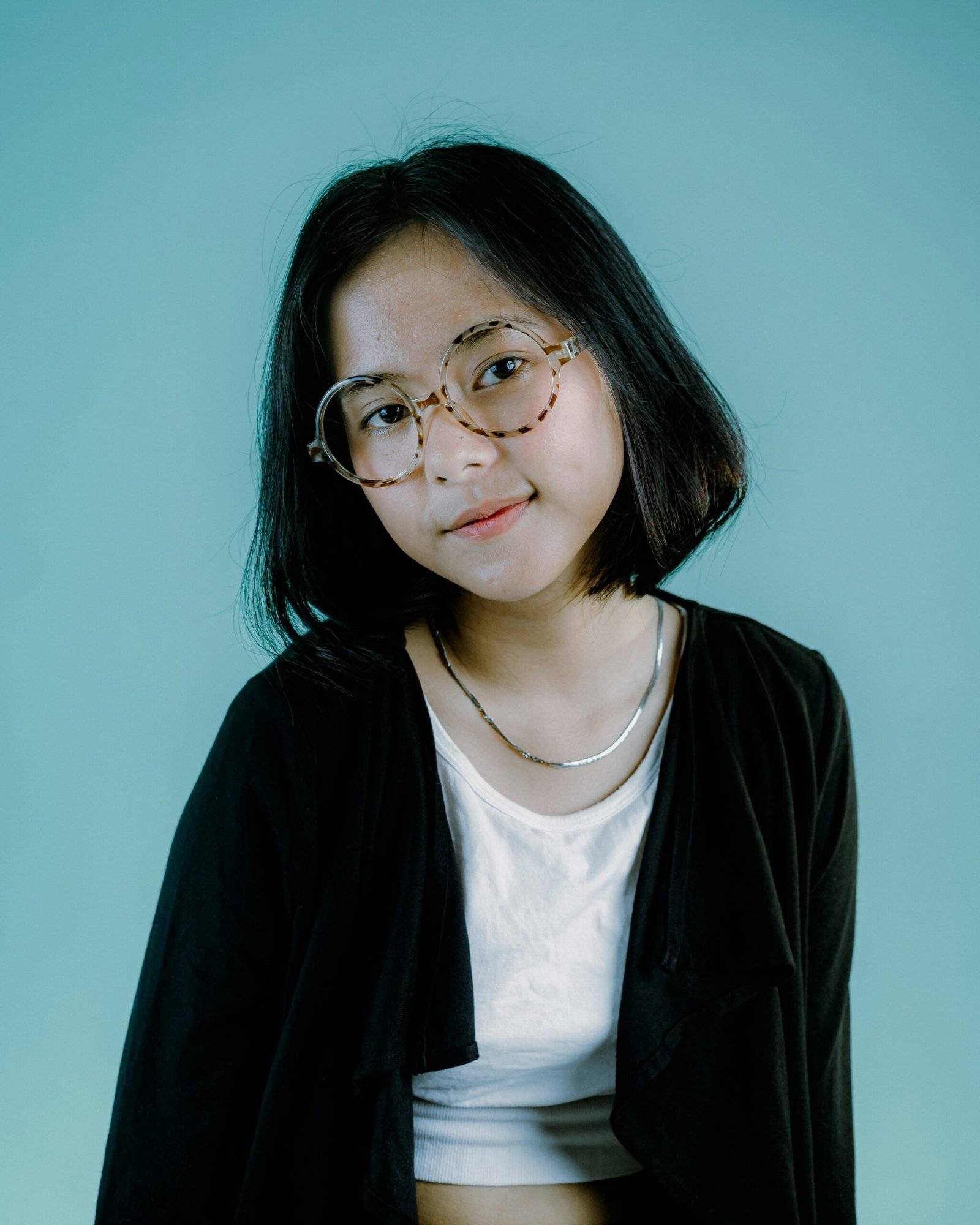 a woman wearing glasses and a white shirt